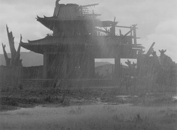 Movie still from “Rashomon” (1950), directed by Akira Kurosawa – An old photo of an asian building in the rain; Extreme Wide shot, Low angle