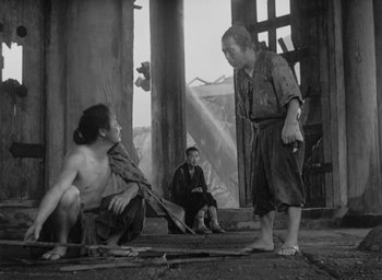 Movie still from “Rashomon” (1950), directed by Akira Kurosawa – A man and a woman in a black and white photo; Wide shot, Low angle