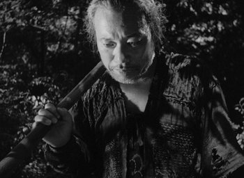 Movie still from “Rashomon” (1950), directed by Akira Kurosawa – A man holding a knife in his hand; Medium shot, High angle