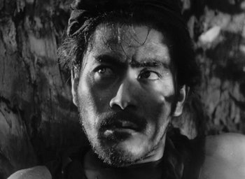 Movie still from “Rashomon” (1950), directed by Akira Kurosawa – Black and white photograph of a man with a beard; Close Up shot, Low angle