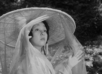 Movie still from “Rashomon” (1950), directed by Akira Kurosawa – A black and white photo of a woman with a parasol; Close Up shot, Low angle