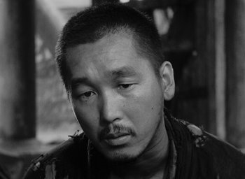 Movie still from “Rashomon” (1950), directed by Akira Kurosawa – Black and white photograph of a man with a mustache; Close Up shot, High angle