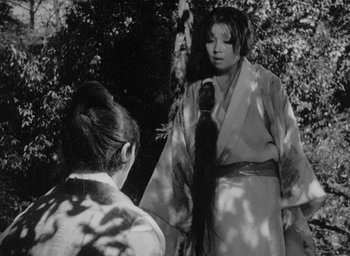 Movie still from “Rashomon” (1950), directed by Akira Kurosawa – Two women in traditional japanese garb in a forest; Medium shot, Over the shoulder angle