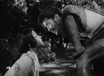 Movie still from “Rashomon” (1950), directed by Akira Kurosawa – A man and a woman in a field with mud on their faces; Medium shot, Low angle