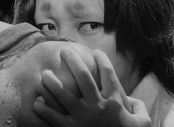 Movie still from “Rashomon” (1950), directed by Akira Kurosawa – A young girl covering her mouth with her hands; Extreme Close Up shot, Over the shoulder angle