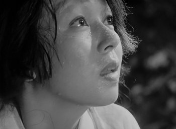 Movie still from “Rashomon” (1950), directed by Akira Kurosawa – Black and white photograph of a woman looking up; Extreme Close Up shot, Low angle