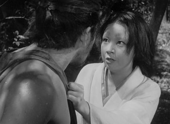 Movie still from “Rashomon” (1950), directed by Akira Kurosawa – A woman is tying a man's tie around his neck; Close Up shot, Over the shoulder angle