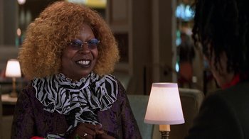 Movie still from “Rat Race” (2001), directed by Jerry Zucker – A woman sitting in front of a table with a lamp; Close Up shot, Over the shoulder angle