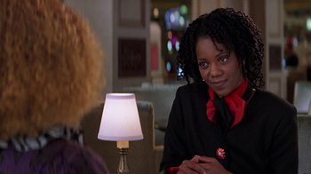 Movie still from “Rat Race” (2001), directed by Jerry Zucker – A woman sitting at a table in front of a lamp; Close Up shot, Over the shoulder angle