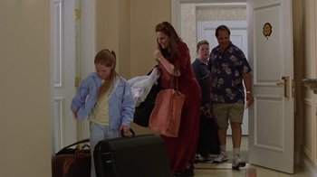 A woman and a girl are pulling suitcases