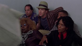 Movie still from “Rat Race” (2001), directed by Jerry Zucker – A group of people sitting next to each other in a room; Medium shot, High angle