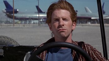 Movie still from “Rat Race” (2001), directed by Jerry Zucker – A man with long red hair driving a car; Close Up shot, Low angle