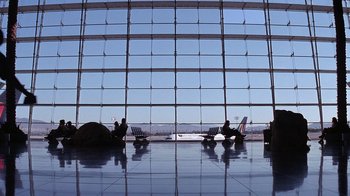 Movie still from “Rat Race” (2001), directed by Jerry Zucker – Two people sitting in an airport waiting for their flight; Extreme Wide shot, Low angle