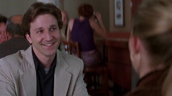 Movie still from “Rat Race” (2001), directed by Jerry Zucker – A man sitting in front of a woman in a room; Close Up shot, Over the shoulder angle