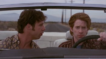 Movie still from “Rat Race” (2001), directed by Jerry Zucker – Two men sitting in the back seat of a car; Medium shot, Over the shoulder angle