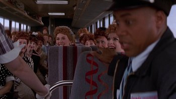 Movie still from “Rat Race” (2001), directed by Jerry Zucker – A group of people riding on a bus; Medium shot, Over the shoulder angle