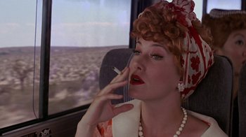 Movie still from “Rat Race” (2001), directed by Jerry Zucker – A woman smoking a cigarette while sitting in a car; Close Up shot, Low angle
