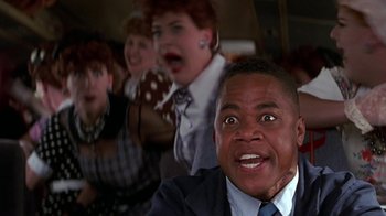 Movie still from “Rat Race” (2001), directed by Jerry Zucker – A group of people on a bus with a man in a suit looking surprised; Close Up shot, Low angle