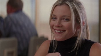 Movie still from “Rat Race” (2001), directed by Jerry Zucker – A beautiful blonde woman smiling for the camera; Close Up shot, Over the shoulder angle
