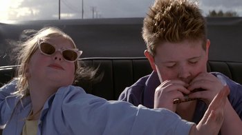 Movie still from “Rat Race” (2001), directed by Jerry Zucker – Two young people sitting in a car , one of which is smoking a cigarette; Close Up shot, Low angle