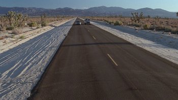 Movie still from “Rat Race” (2001), directed by Jerry Zucker – Two cars driving down a snow covered road; Extreme Wide shot, High angle