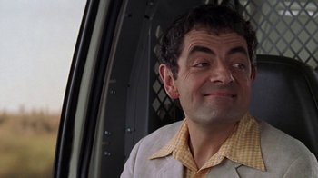 Movie still from “Rat Race” (2001), directed by Jerry Zucker – A person wearing a jacket and a checkered shirt; Close Up shot, Over the shoulder angle