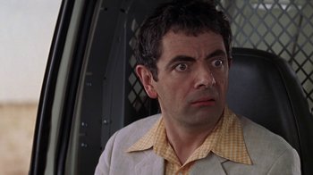 Movie still from “Rat Race” (2001), directed by Jerry Zucker – A person wearing a suit and tie; Close Up shot, Over the shoulder angle