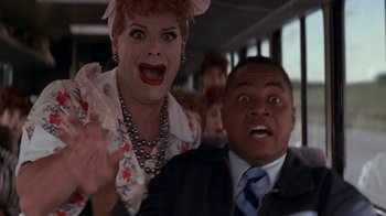 Movie still from “Rat Race” (2001), directed by Jerry Zucker – A woman and a man are on a bus together; Close Up shot, Low angle