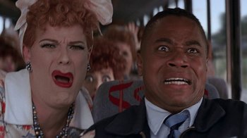 Movie still from “Rat Race” (2001), directed by Jerry Zucker – A man and a woman are in a bus; Close Up shot, Low angle