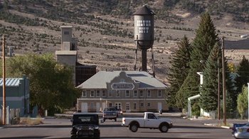 Movie still from “Rat Race” (2001), directed by Jerry Zucker – A building with a water tower on top of it near a road; Extreme Wide shot, High angle