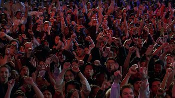 Movie still from “Rat Race” (2001), directed by Jerry Zucker – A large crowd of people with their hands up; Medium shot, High angle