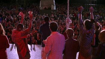 Movie still from “Rat Race” (2001), directed by Jerry Zucker – A group of people standing in front of an audience; Wide shot, High angle