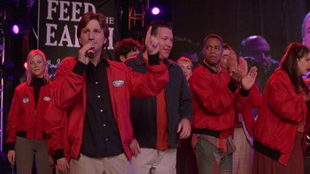 Movie still from “Rat Race” (2001), directed by Jerry Zucker – A group of men in red jackets singing and clapping; Medium shot, Low angle