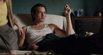 A man sitting on a couch holding a cell phone