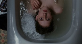 A young boy is in a tub of water