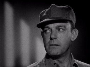 Movie still from “Raw Deal” (1948), directed by Anthony Mann – A man wearing a hat and looking to his left; Close Up shot, Low angle