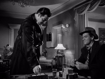 Movie still from “Raw Deal” (1948), directed by Anthony Mann – Two men in a living room , one of which is playing a video game; Medium shot, Low angle