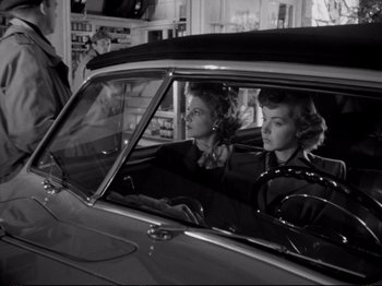 Movie still from “Raw Deal” (1948), directed by Anthony Mann – A couple of women sitting in the back seat of a car; Medium shot, Low angle