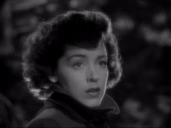 Movie still from “Raw Deal” (1948), directed by Anthony Mann – A black - and - white photo of a woman in a jacket; Close Up shot, High angle