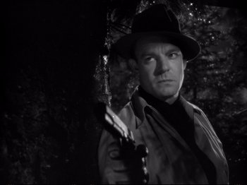 Movie still from “Raw Deal” (1948), directed by Anthony Mann – A black and white photo of a man holding a gun; Close Up shot, Low angle