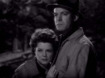 Movie still from “Raw Deal” (1948), directed by Anthony Mann – A man and a woman standing next to each other; Close Up shot, Low angle