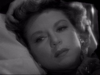 Movie still from “Raw Deal” (1948), directed by Anthony Mann – An old photo of a woman laying on the ground; Close Up shot, High angle