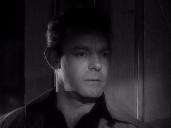 Movie still from “Raw Deal” (1948), directed by Anthony Mann – Black and white photograph of a man in a black shirt; Close Up shot, High angle