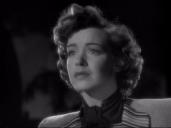 Movie still from “Raw Deal” (1948), directed by Anthony Mann – An old photo of a woman in a suit looking up; Close Up shot, Low angle