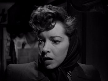 Movie still from “Raw Deal” (1948), directed by Anthony Mann – A black and white photo of a woman with a scarf around her neck; Close Up shot, Low angle