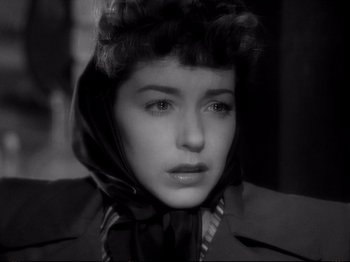 Movie still from “Raw Deal” (1948), directed by Anthony Mann – A black and white photo of a woman wearing a scarf; Close Up shot, High angle