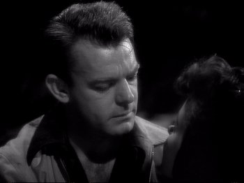 Movie still from “Raw Deal” (1948), directed by Anthony Mann – A black and white photo of a man and a woman; Close Up shot, Over the shoulder angle
