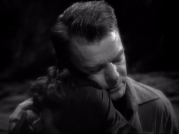 Movie still from “Raw Deal” (1948), directed by Anthony Mann – A black and white photo of a man and a woman hugging; Close Up shot, High angle