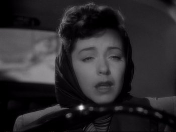 Movie still from “Raw Deal” (1948), directed by Anthony Mann – A black and white photo of a woman in a car; Close Up shot, High angle