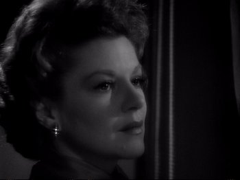 Movie still from “Raw Deal” (1948), directed by Anthony Mann – A black - and - white photo of a woman looking at the camera; Close Up shot, Low angle